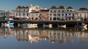 Um areal à beira-mar, com barcos atracados e edifícios ao longo da costa.