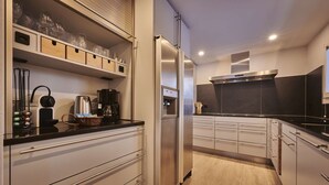 A modern kitchen with stainless steel appliances, wooden cabinets, and a black countertop.