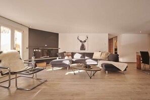 A modern living room with a sofa set, a coffee table, and a fireplace.