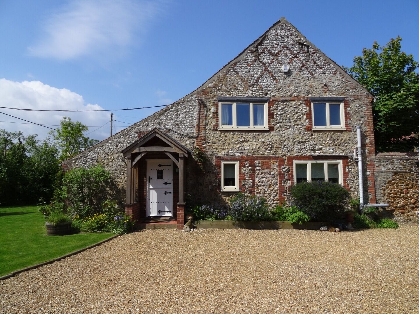 A stone house with a gabled roof, a front door, and two windows.