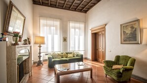 Una sala de estar con un sofá verde, una mesa de centro de madera y un sillón verde.