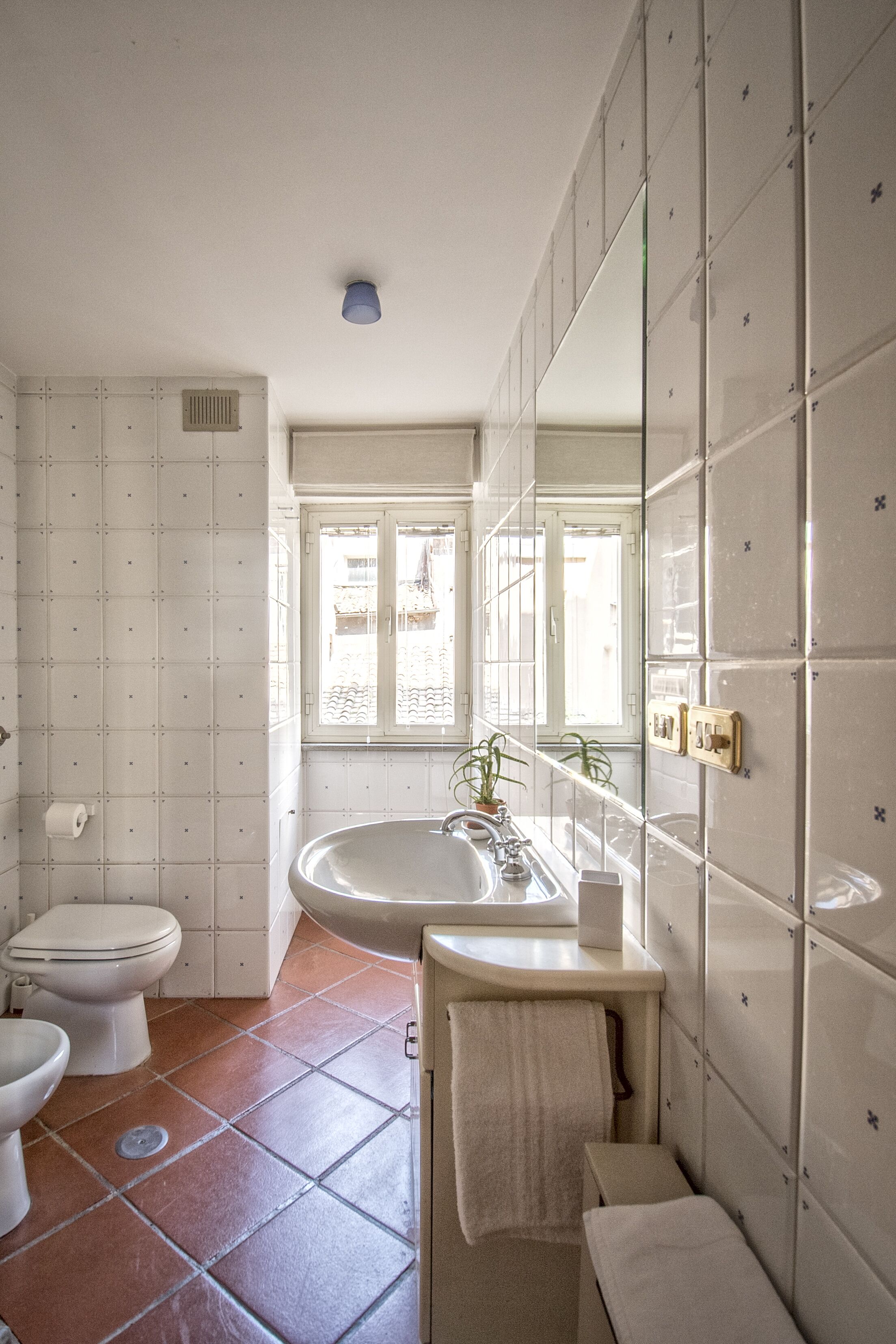 Un baño con inodoro, lavabo y ventana.