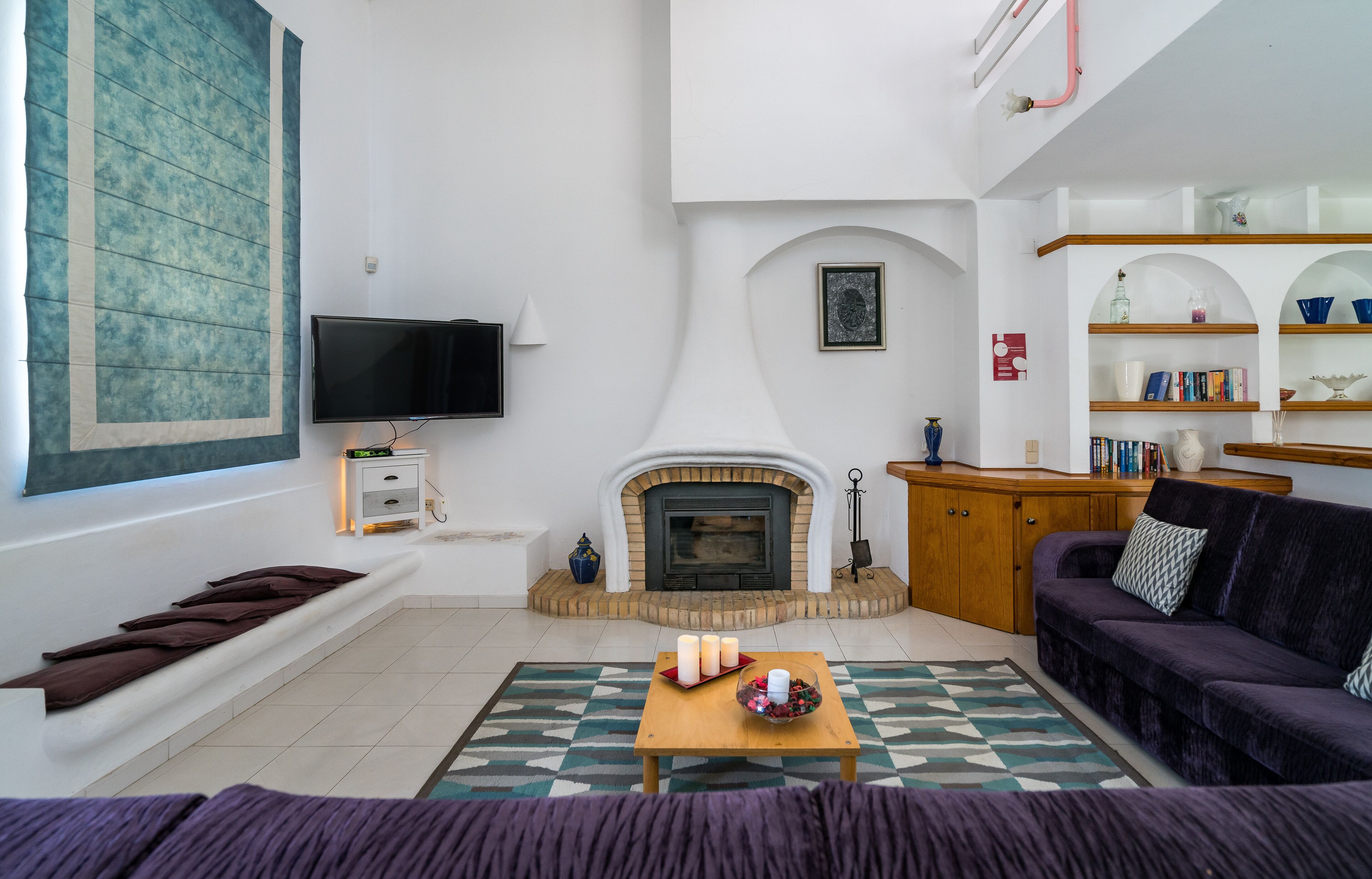 A living room with a fireplace, a television, a sofa, and a coffee table.
