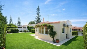 A modern house with a well-maintained lawn, satellite dish, and a small garden area. - Beautiful 4 Bedroom Villa Silva, Private Pool, Close To The Strip And Old Town (Albufeira)