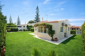Ein modernes Haus mit gepflegtem Rasen, Satellitenschüssel und einem kleinen Garten.