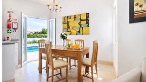 A dining area with a table, chairs, a chandelier, and a painting on the wall. - Beautiful 4 Bedroom Villa Silva, Private Pool, Close To The Strip And Old Town (Albufeira)