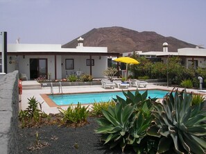 Una piscina al aire libre, una piscina climatizada, tumbonas
