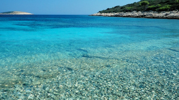 A clear turquoise sea with a rocky shoreline and a small island in the distance. - Luxury seafront villa, stunning sea & harbour views, on unspoilt island of Vis (Vis)