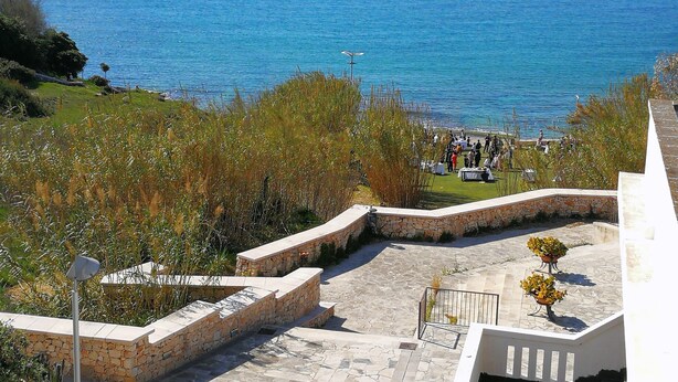 A coastal view with a stone staircase leading down to a grassy area with a table and chairs, overlooking the sea. - VILLA SEA SALENTO (Marina San Gregorio)