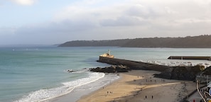 A coastal beach with a lighthouse, rocky shoreline, and a pier with boats. - House / Villa - BINIC (BINIC)