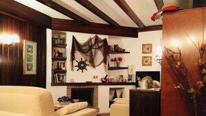 Un salon chaleureux avec une cheminée, une bibliothèque et une décoration murale.