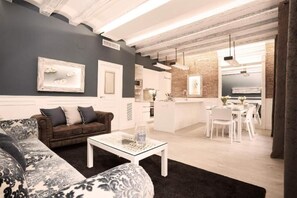 Uma sala de estar moderna com um sofá, uma mesa de centro e uma área de jantar com cadeiras e uma mesa.