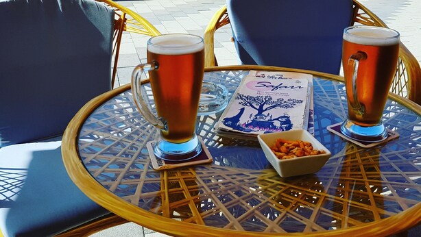 A table with two beer mugs and a menu at a seaside view. - Enjoy the sun, sand and salty sea in a stylish floor on the first line (Torrox)