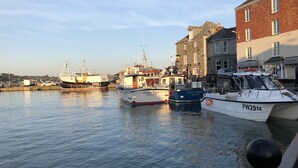 A harbor with several boats docked, a stone building, and a clear sky. - A Delightful 19th Century Beamed Cottage In Trevone Bay, 3 Mins From The Beach (Padstow)