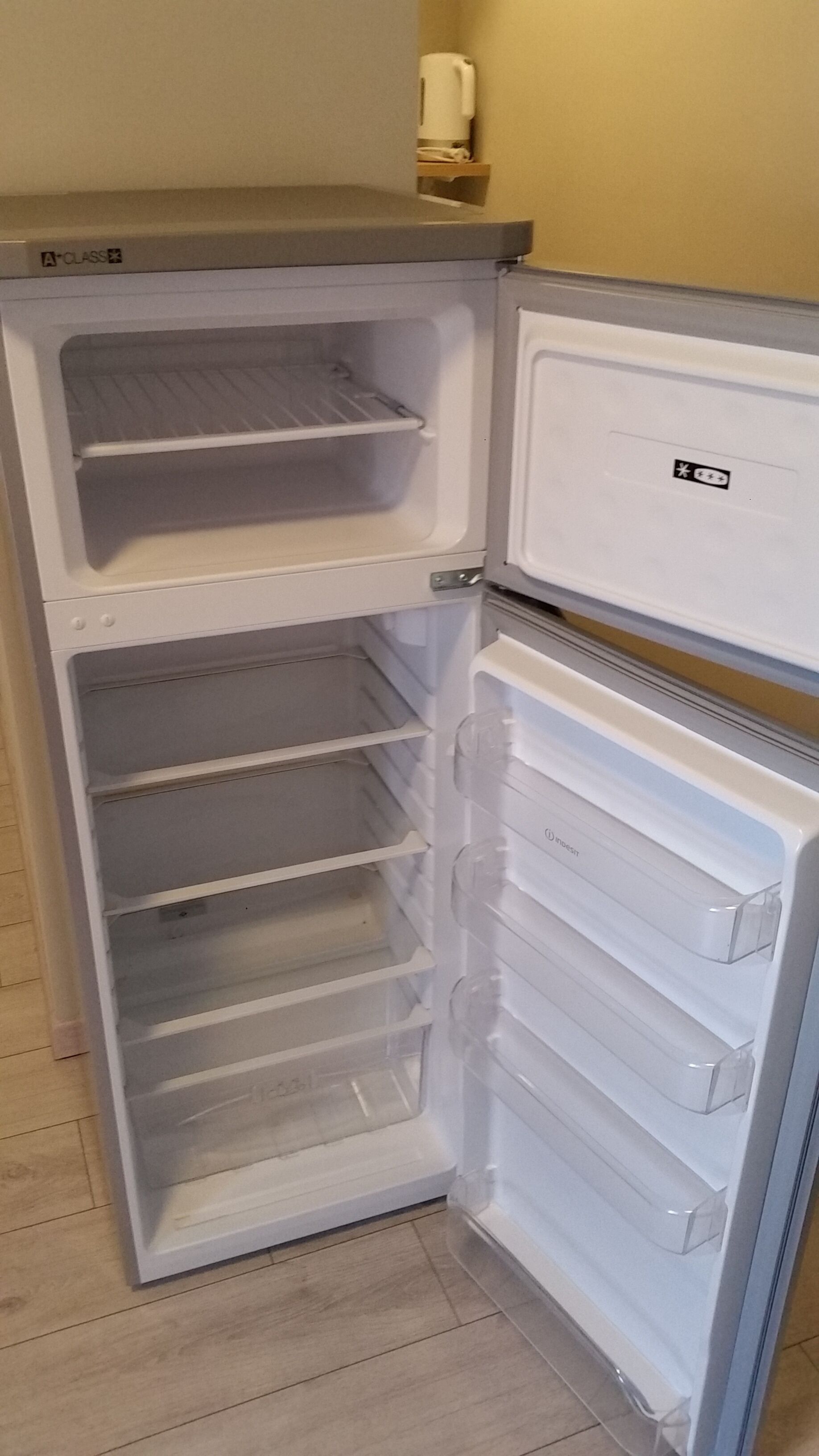 Un refrigerador blanco con dos repisas en las puertas y varios cajones.
