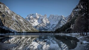 Un paysage montagneux avec un lac aux eaux limpides dans lequel se reflètent les sommets.