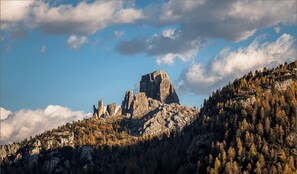 Un paisaje montañoso con picos rocosos y bosques densos.