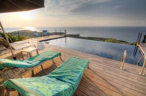 An infinity pool with lounge chairs and a wooden deck overlooking the sea. - Villa 130m2, 180° panoramic sea view, 5 pers. heated infinity pool (Corbara)