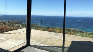 Un balcon offrant une vue dégagée sur l’océan et une côte lointaine.