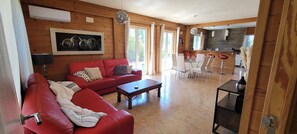 A spacious living room with a red sofa, a coffee table, and a dining area with white chairs. - The Palms - Spacious Private Villa For Family  Fun & Relaxation (L'Ametlla de Mar)