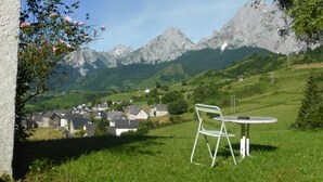 A grassy area with a metal chair and table, overlooking a village and mountains. - House / Villa - Lescun (Lescun)