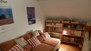 A cozy living room with a brown sofa, a bookshelf filled with books, and a framed picture on the wall. - House / Villa - Lescun (Lescun)