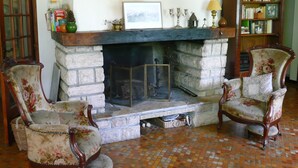 A room with a fireplace, two floral armchairs, a bookshelf, and a door. - House / Villa - Lescun (Lescun)