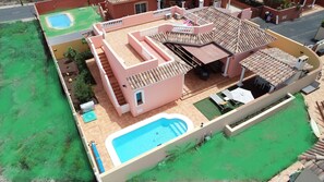 A two-story house with a swimming pool, a covered patio, and a small garden area. -  VILLA "BELLA LUCIA 1" PRIVATE HEATED POOL, WIFI, BARBECUE, SATELLITE TV  (corralejo- la oliva)