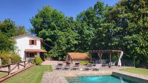 A pool area with lounge chairs, a pergola, and a small building with a red-tiled roof. - Totally private cottage with own pool, amazing views and close to Barga!  WIFI (Barga)