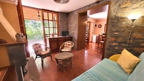 A cozy living area with a sofa, two wicker chairs, a coffee table, and a stone wall. - Totally private cottage with own pool, amazing views and close to Barga!  WIFI (Barga)
