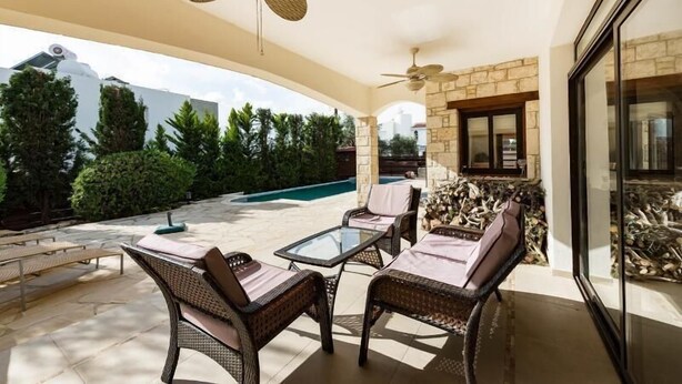 An outdoor patio with wicker furniture, a glass table, and a ceiling fan. - Beautiful Stone Villa with large pool, close to beaches plus free use of car : ) (Coral Bay, Peyia)