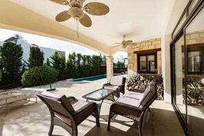 An outdoor patio with wicker furniture, a glass table, and a ceiling fan. - Beautiful Stone Villa with large pool, close to beaches plus free use of car : ) (Coral Bay, Peyia)
