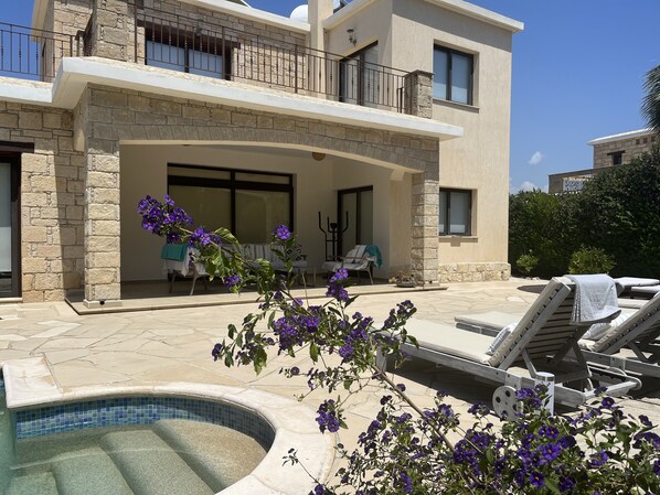 A two-story house with a stone facade, a covered patio with outdoor furniture, and a swimming pool. - Beautiful Stone Villa with large pool, close to beaches plus free use of car : ) (Coral Bay, Peyia)