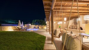 An outdoor patio area with lounge chairs, a swing, and a pool. - Kalypso Villa, a Serene Family Retreat with Pool (Rethymno)