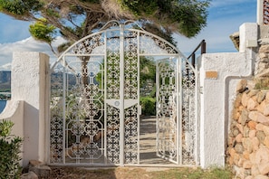 Stunning entrance to a residence, featuring an ornate metal gate and pathway.
