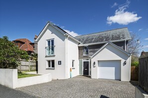 Ein zweigeschossiges Wohngebäude mit Garage, Auffahrt und kleinem Garten.