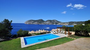 Une piscine avec vue sur la mer et les montagnes.