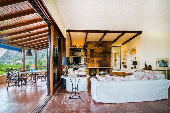 A spacious living area with a fireplace, a television, and a dining set.