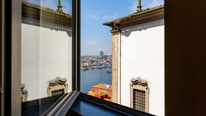 A view from a window overlooking a cityscape with buildings and a river.