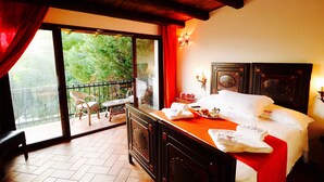 A hotel room with a balcony, a bed with white linens, a wooden headboard, and a red accent wall. - Otranto: SPLENDID TENUTA WITH POOL AND TENNIS COURSE. (Muro Leccese)