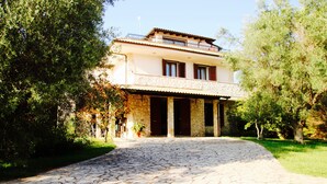A two-story stone building with a stone pathway leading to the entrance. - Otranto: SPLENDID TENUTA WITH POOL AND TENNIS COURSE. (Muro Leccese)