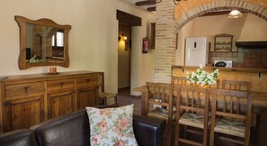 A cozy living room with a wooden sofa, a dining table with chairs, a wooden cabinet, and a mirror on the wall. - Cottage n��9 for 6 people, Batan Rio Tus (Yeste)