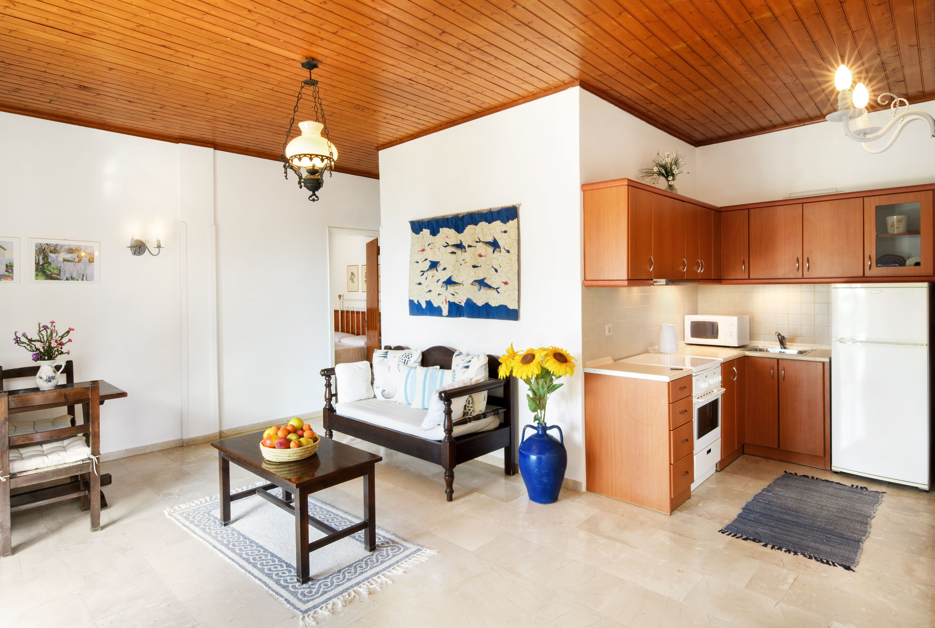 A modern kitchen with wooden cabinets, a white refrigerator, and a microwave.