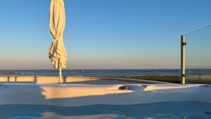 A hot tub with a view of the ocean and a white umbrella. - Top Apt With Roof Terrace, Stunning 180º Atlantic Ocean and Ria Formosa View! (Fuseta)