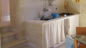 A compact kitchen with a sink, cabinets, and a stove. - House / Villa - FAVIGNANAHouse with garden (Favignana)
