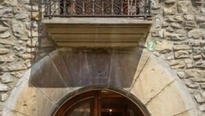 A stone building with a wooden door and an arched entrance.