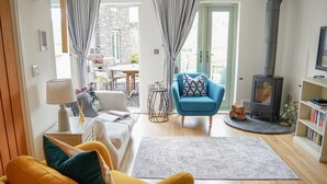 Ein gemütliches Wohnzimmer mit einer Couch, einem Sessel und einem Kamin.