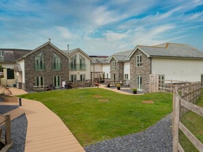 A residential area with stone and brick houses, a wooden deck, and a grassy lawn.