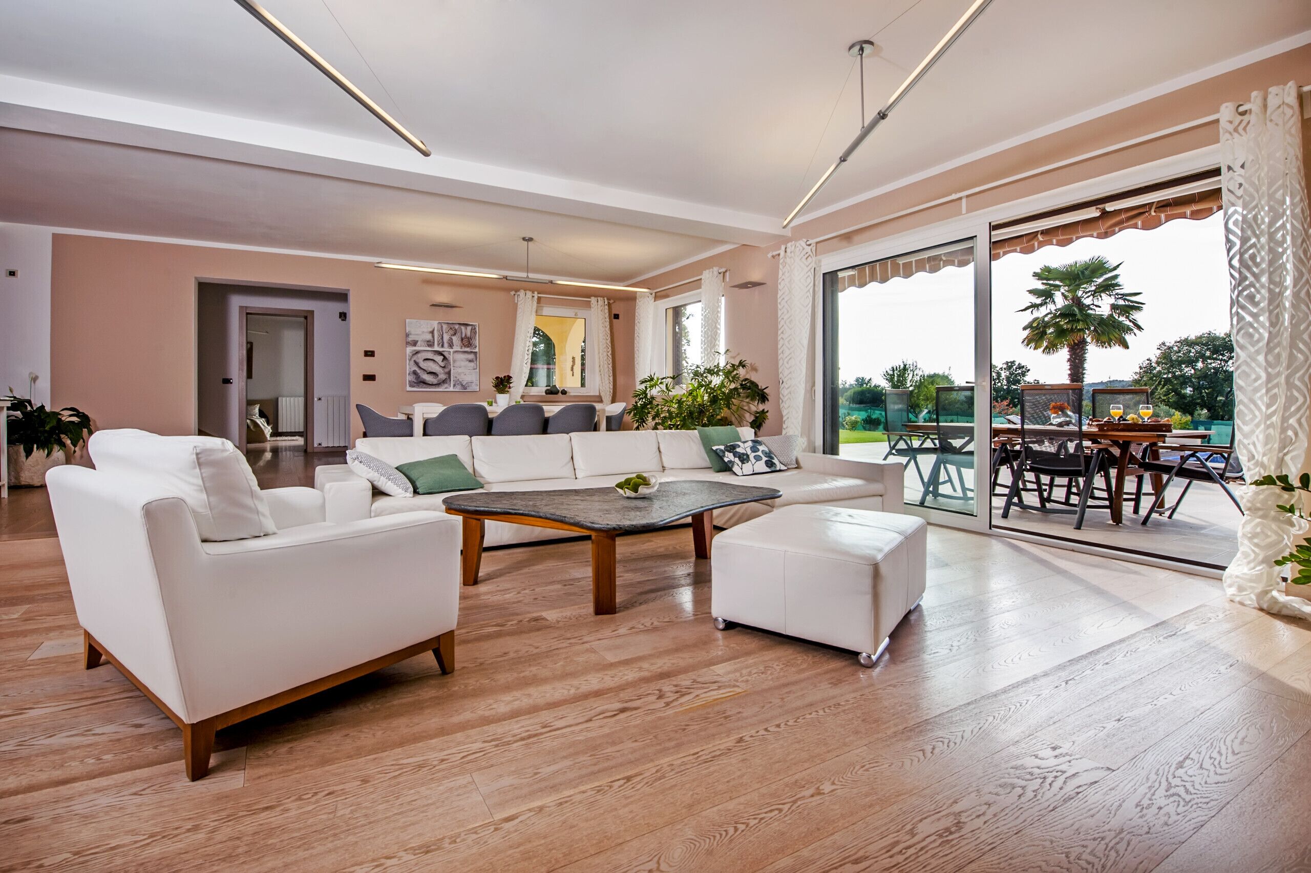 A spacious living room with a sofa, coffee table, and a dining area with a table and chairs.