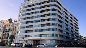 A multi-story hotel with a curved facade, large windows, and a prominent entrance. - Stunning Seafront Penthouse w/ Private Sun Terrace & Direct Panoramic Sea Views (Kings Road)